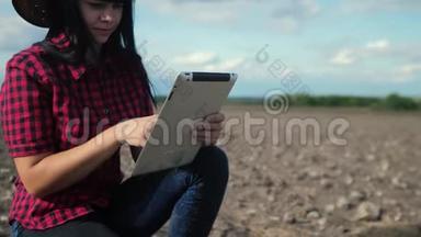 智慧生态是一种收获农业的耕作理念。 女农民用数字平板电脑研究生活方式中的泥土
